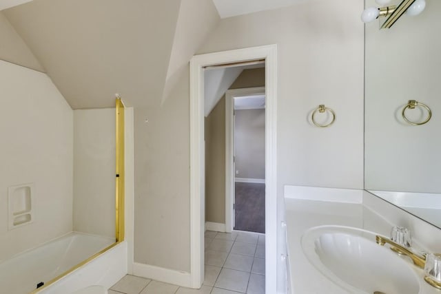 bathroom featuring tile patterned floors, bathtub / shower combination, vaulted ceiling, and vanity