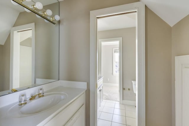 bathroom with tile patterned flooring, vanity, and vaulted ceiling