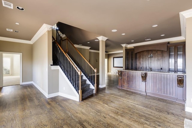 kitchen featuring ornate columns, crown molding, dark brown cabinets, and dark hardwood / wood-style flooring