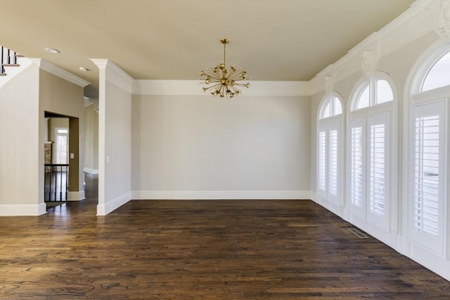 spare room with an inviting chandelier, crown molding, and dark hardwood / wood-style floors