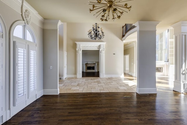 foyer entrance featuring hardwood / wood-style flooring, crown molding, and ornate columns