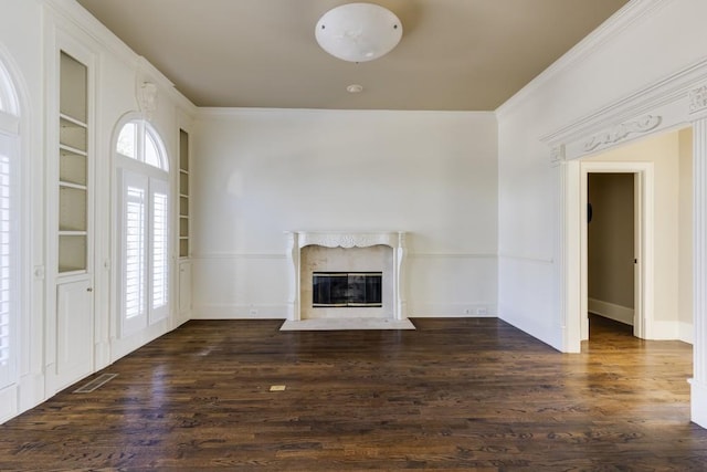 unfurnished living room with dark hardwood / wood-style flooring, crown molding, built in features, and a high end fireplace