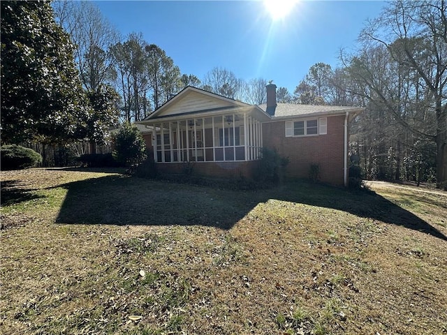 back of property featuring a yard and a sunroom