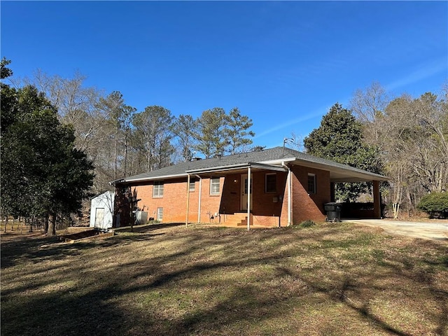 exterior space with a carport, a storage unit, and a yard