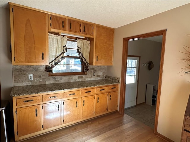 kitchen featuring backsplash, dark wood-type flooring, and a wealth of natural light