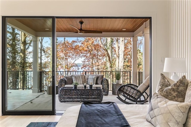 sunroom featuring wood ceiling, a healthy amount of sunlight, and ceiling fan