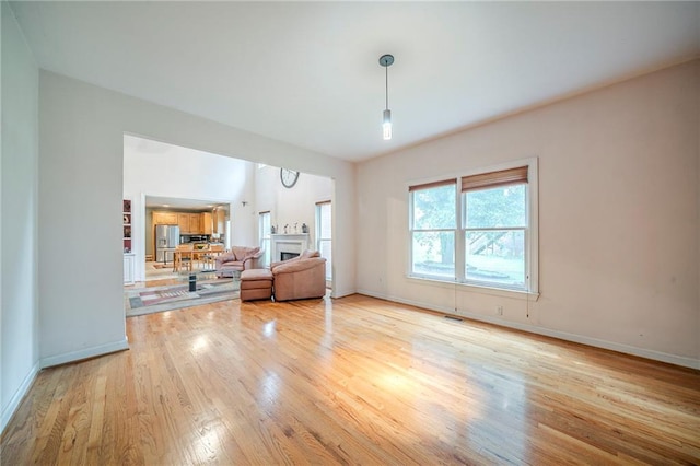 unfurnished living room featuring light wood finished floors, baseboards, and visible vents