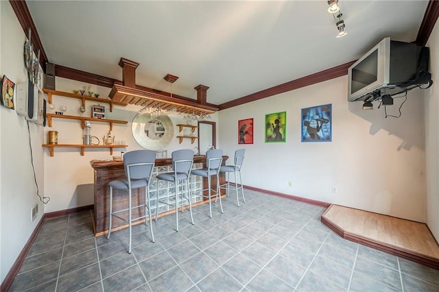 bar with tile patterned floors, visible vents, baseboards, and ornamental molding
