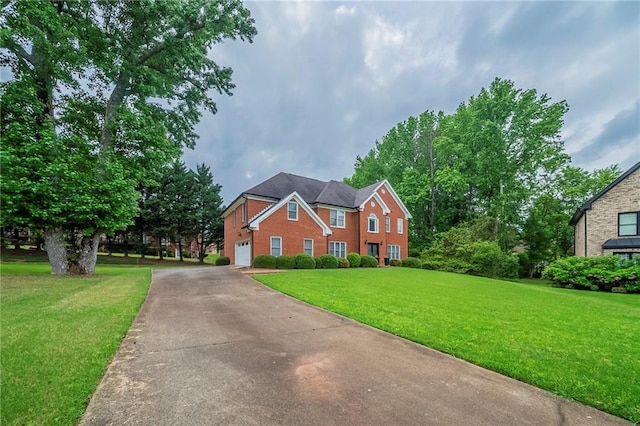 view of front of home featuring concrete driveway, a garage, and a front lawn