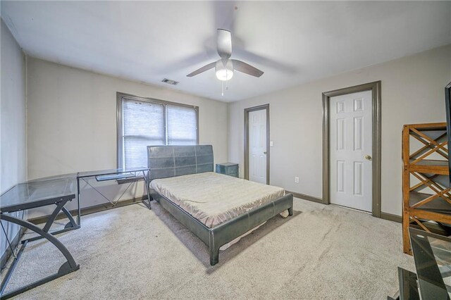 carpeted bedroom with visible vents, baseboards, and a ceiling fan