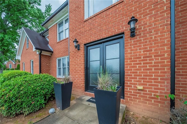 view of side of home featuring french doors and brick siding