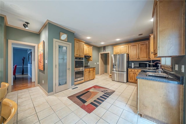 kitchen with a sink, ornamental molding, light tile patterned flooring, and appliances with stainless steel finishes