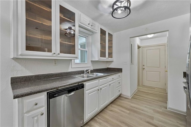 kitchen featuring white cabinetry, dishwasher, a textured ceiling, and sink