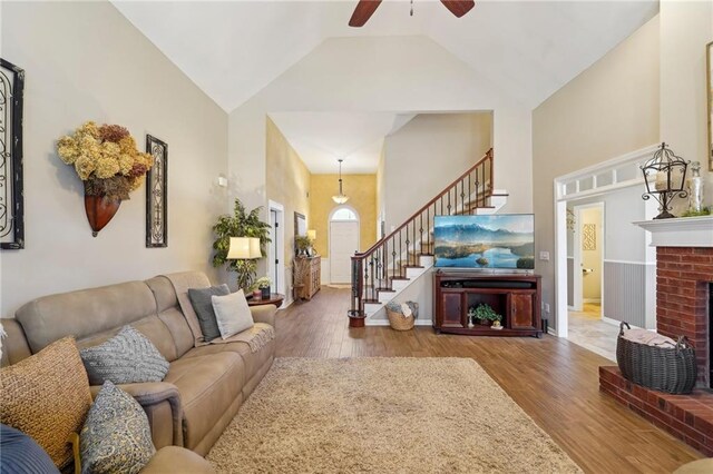 living room featuring high vaulted ceiling, a fireplace, and hardwood / wood-style floors