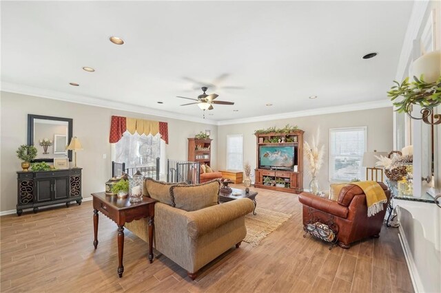 living room with crown molding, ceiling fan, and light hardwood / wood-style floors