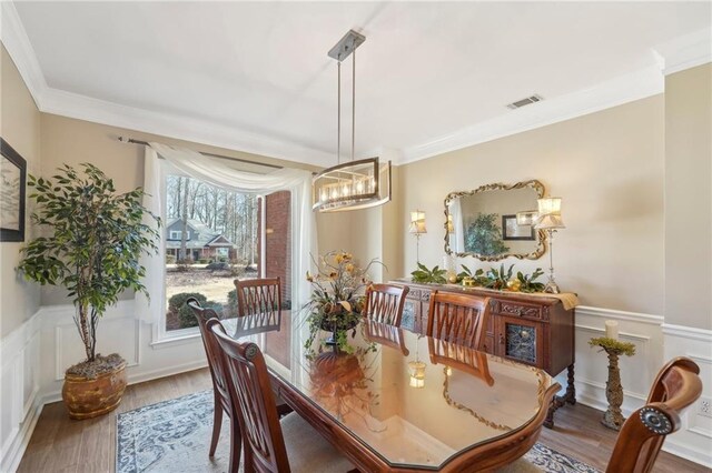 dining space featuring hardwood / wood-style flooring and crown molding