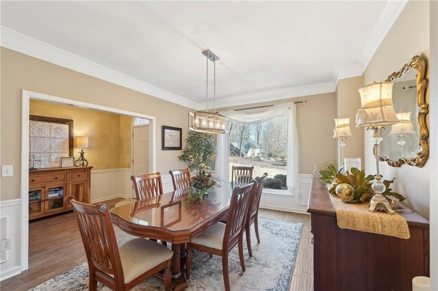 dining area with hardwood / wood-style flooring and ornamental molding