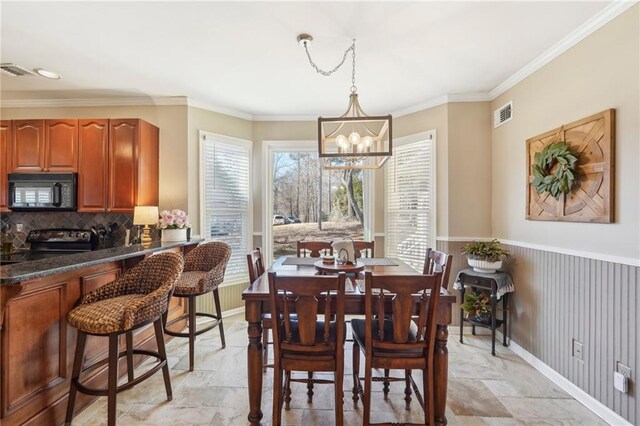 dining space featuring crown molding and an inviting chandelier