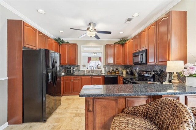 kitchen featuring sink, a breakfast bar area, crown molding, kitchen peninsula, and black appliances