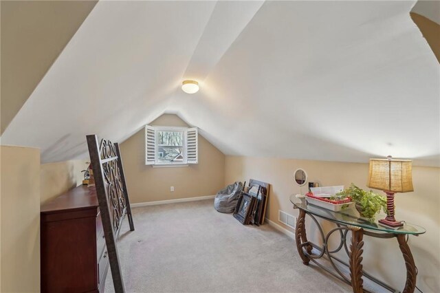 bonus room featuring lofted ceiling and light colored carpet