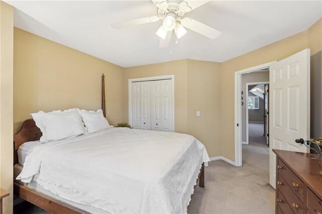 carpeted bedroom with ceiling fan and a closet