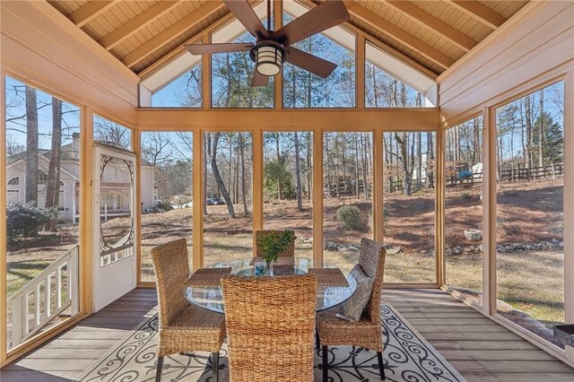 sunroom / solarium featuring ceiling fan, lofted ceiling with beams, and wooden ceiling