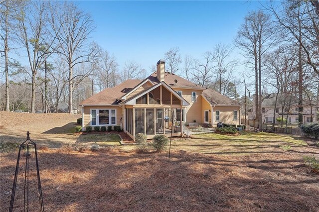 rear view of property featuring a sunroom