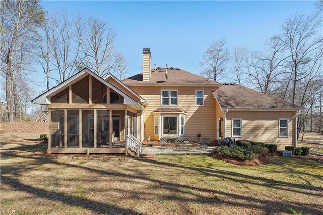 back of house featuring a sunroom, a patio area, and a lawn