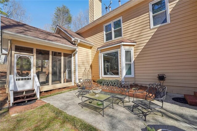 rear view of property with a patio area and a sunroom