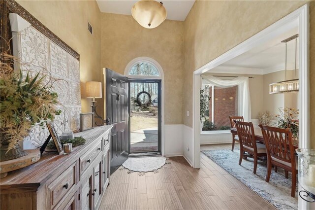 foyer with a towering ceiling and hardwood / wood-style floors