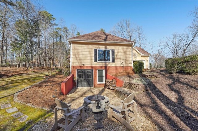 back of house featuring an outdoor fire pit