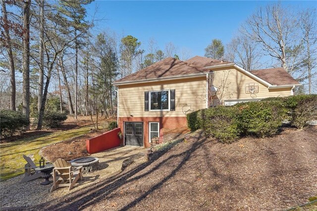 view of side of home featuring an outdoor fire pit