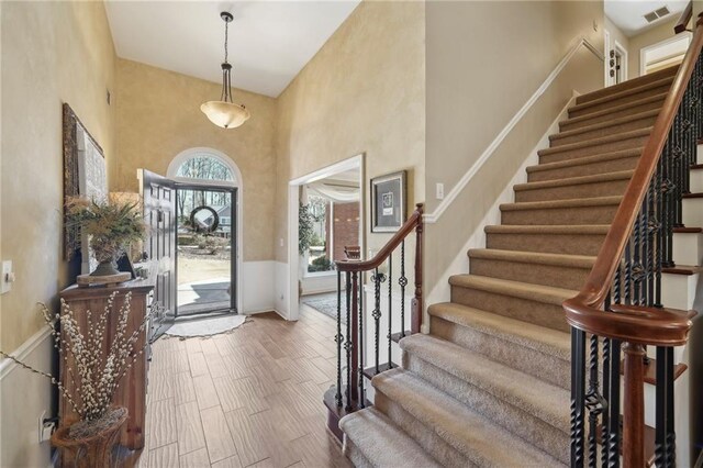 entryway featuring wood-type flooring and a high ceiling