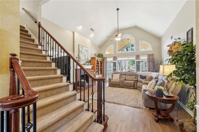 living room featuring ceiling fan, hardwood / wood-style floors, and high vaulted ceiling