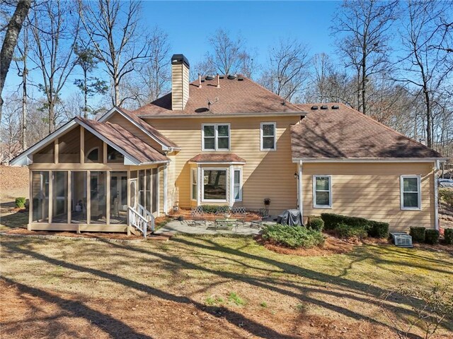 back of house featuring a patio, a sunroom, central AC, and a lawn