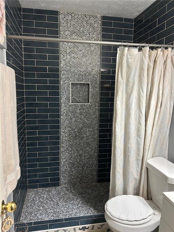 6658 Ramsgate Way, Norcross, GA 30093 - full bath with toilet, tiled shower, tile patterned floors, a textured ceiling, and vanity