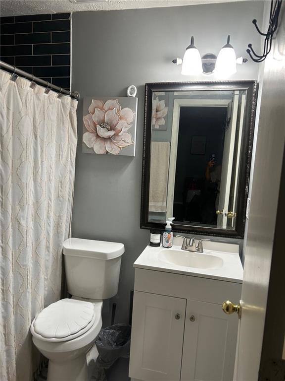 6658 Ramsgate Way, Norcross, GA 30093 - bathroom featuring toilet, vanity, and a shower with curtain