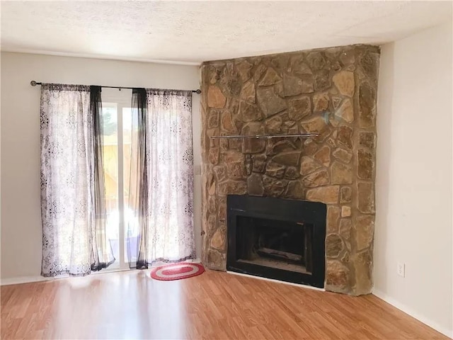6658 Ramsgate Way, Norcross, GA 30093 - unfurnished living room featuring wood finished floors, a large fireplace, and baseboards