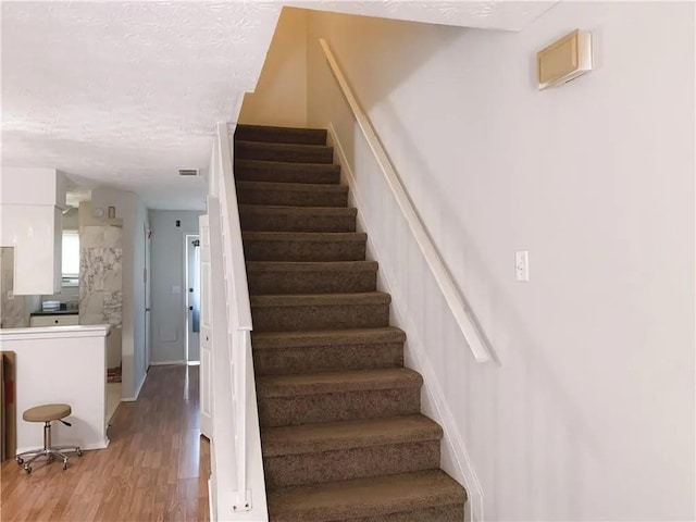 6658 Ramsgate Way, Norcross, GA 30093 - stairs with wood finished floors and a textured ceiling