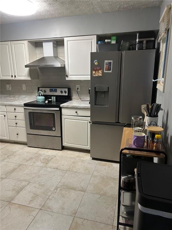 6658 Ramsgate Way, Norcross, GA 30093 - kitchen featuring stainless steel appliances, wall chimney exhaust hood, light countertops, white cabinets, and a textured ceiling
