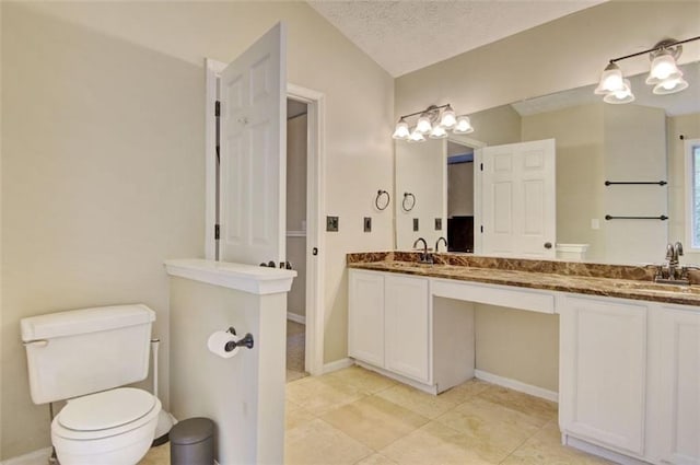 bathroom with vanity, tile patterned flooring, toilet, and a textured ceiling