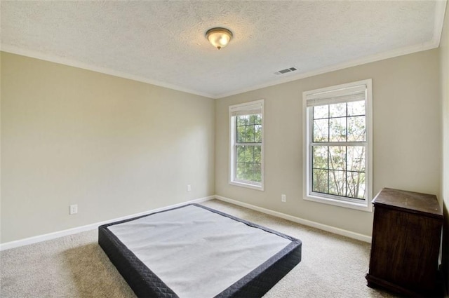 bedroom with crown molding, a textured ceiling, and carpet flooring