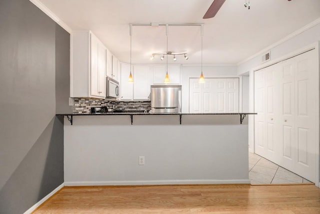 1445 Monroe Dr NE Unit F10, Atlanta, GA 30324 - kitchen with refrigerator, stainless steel microwave, a ceiling fan, a peninsula, and track lighting