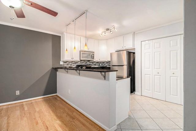 1445 Monroe Dr NE Unit F10, Atlanta, GA 30324 - kitchen with appliances with stainless steel finishes, a peninsula, ceiling fan, white cabinets, and dark countertops