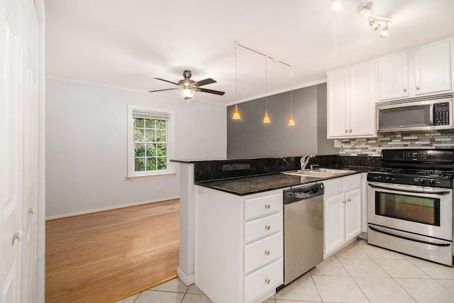1445 Monroe Dr NE Unit F10, Atlanta, GA 30324 - kitchen featuring stainless steel appliances, a sink, track lighting, a peninsula, and white cabinetry