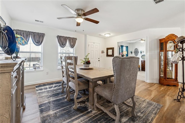 dining area featuring ceiling fan, wood finished floors, visible vents, and baseboards