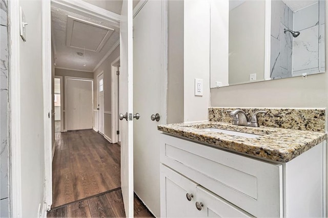 bathroom featuring wood finished floors, vanity, and crown molding