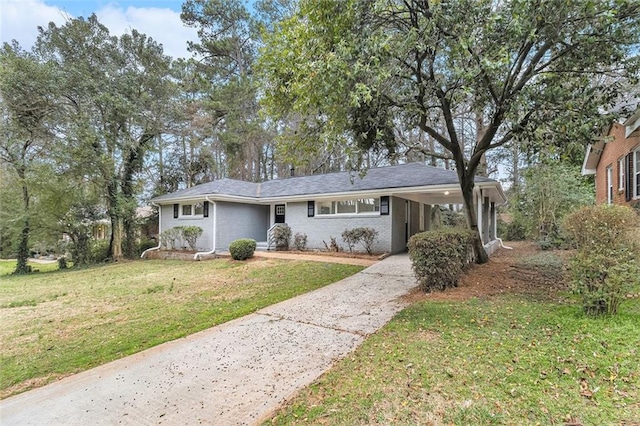 ranch-style house featuring driveway, a front lawn, an attached carport, and brick siding