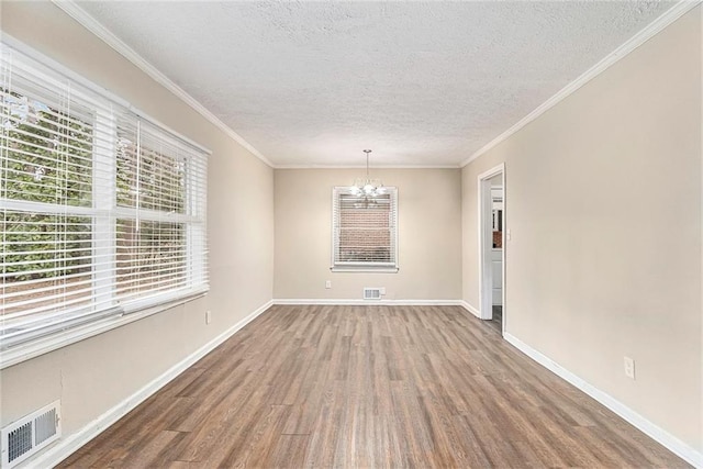 unfurnished dining area featuring a chandelier, visible vents, baseboards, and wood finished floors