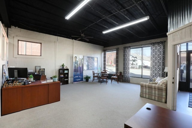 carpeted office space featuring ceiling fan